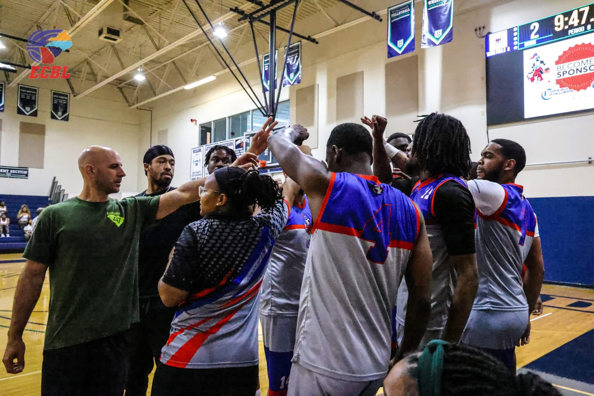 Carolina Crusaders players and coaches joining hands in a team huddle
